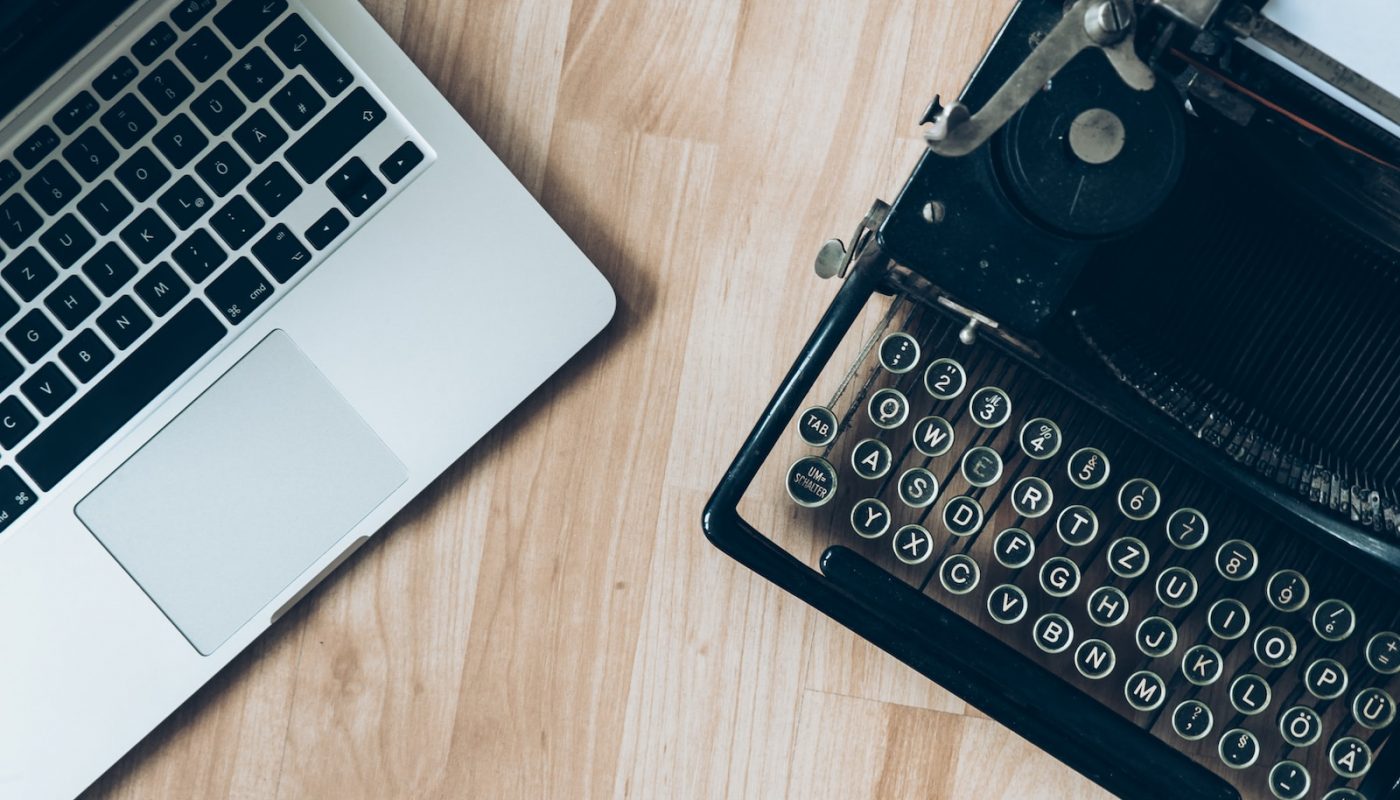 MacBook beside typewriter machine