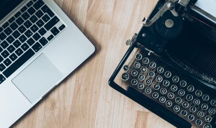 MacBook beside typewriter machine