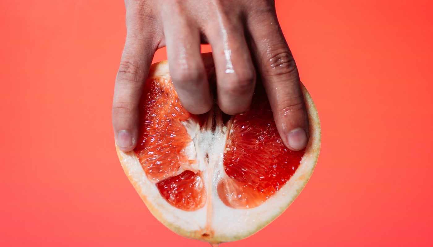 person holding red pomelo fruit